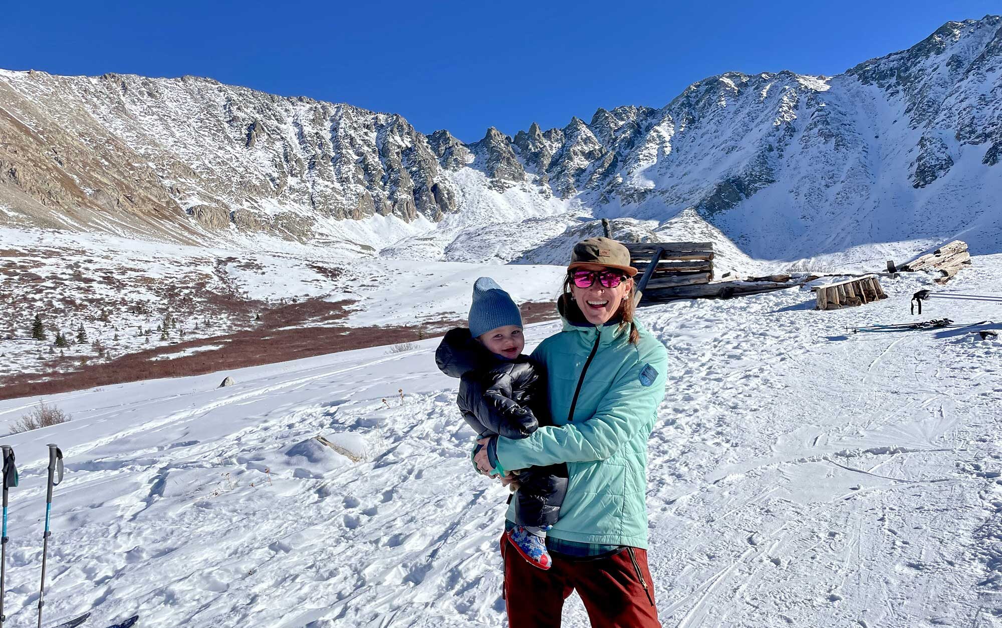 woman holding a baby in the snow in colorado